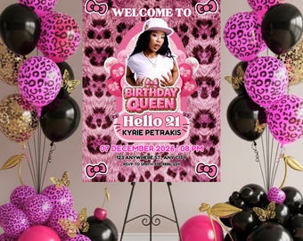May include: A pink and black birthday party welcome sign with a photo of a woman wearing a white hat. The sign reads "Welcome to Birthday Queen Hello 21 Kyrie Petrakis" with event details. Balloons in pink leopard print, black, and gold surround the sign.