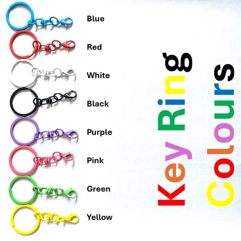 May include: A collection of eight metal key rings with lobster claw clasps, displayed in a vertical column. The colors include blue, red, white, black, purple, pink, green, and yellow. The text "Key Ring Colours" is printed on the right side.