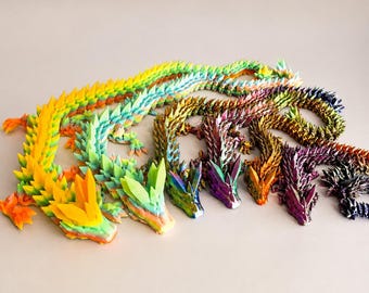 May include: A collection of six articulated dragon figurines featuring segmented bodies with sharp, crystalline-like scales. The dragons are displayed in a variety of vibrant colors, including yellow, orange, green, blue, gold, and purple gradients.