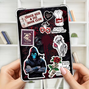 Könnte beinhalten: Eine schwarze Tablet-Hülle mit verschiedenen Aufklebern. Die Aufkleber zeigen gotische und Dark-Romance-Motive, darunter Totenköpfe, Rosen und Sätze wie "Touch Her & Die Book Club" und "Dark Romance".