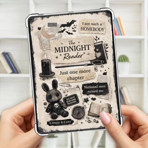 May include: A black and white tablet case with a gothic theme. The case features a plush bunny, bats, a candle, and the text "The Midnight Reader." Additional text includes "Just one more chapter," "Creepy & Cozy," and "I am such a HOMEBODY."