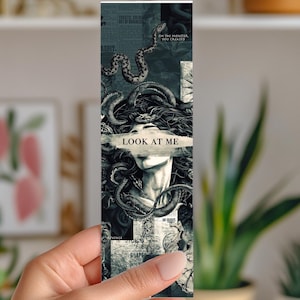 May include: A bookmark featuring a Medusa-like figure with snakes and the text "LOOK AT ME". The design is in grayscale with newspaper-style backgrounds. The bookmark is rectangular and held by a hand.