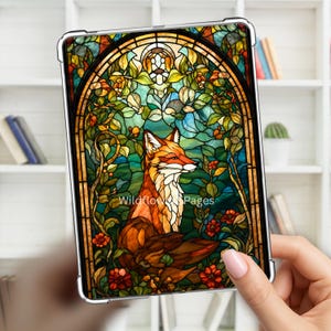 Może przedstawiać: Prostokątne etui na tablet z ilustracją w stylu witrażu przedstawiającą lisa siedzącego wśród zielonych liści i czerwonych kwiatów pod łukowatą ramą. Napis Wildflower Pages jest nadrukowany na biało na środku obrazu z lisem.