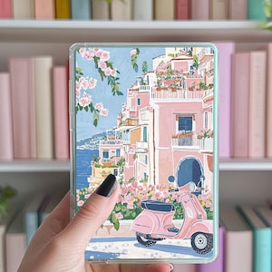 Könnte beinhalten: Eine Illustration eines rosafarbenen Rollers, der vor einem rosafarbenen Gebäude mit blauem Himmel und weißen Wolken im Hintergrund geparkt ist. Das Gebäude hat Balkone mit Blumen und Pflanzen. Der Roller hat einen schwarzen Sitz und ein weißes Lenkrad.