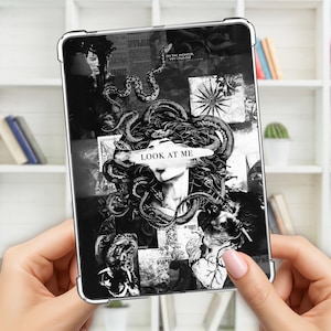 May include: A black and white tablet case featuring a Medusa-inspired design. The artwork includes snakes, a woman's face, and the text "LOOK AT ME". The case is held by a person.
