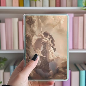 May include: Clear phone case featuring a sepia-toned image of two figures embracing amidst clouds, possibly an angel-themed design. The case has a transparent border and is held against a backdrop of books.
