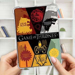 May include: A clear tablet case featuring a colorful design with the words "GAME OF THRONES". The design includes various house sigils and mottos, such as "Hear Roar" and "Winter is Coming". The case is held in front of a white shelf.