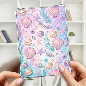 May include: A rectangular tablet case featuring a pastel-colored pattern of seashells, starfish, and seaweed on a glittery background. The design includes various shell shapes in shades of pink, gold, and blue, with the text Wildflower&Pages visible.