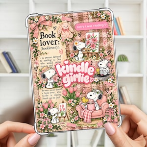 Puede incluir: Una funda transparente para lector electrónico con un collage de ilustraciones de Snoopy, flores rosas y patrones de cuadros. El texto incluye "Book lover: (booklover)n.", "sorry i was reading" y "kindle girlie" en letra rosa. Snoopy aparece pintando, escuchando música y bebiendo café.
