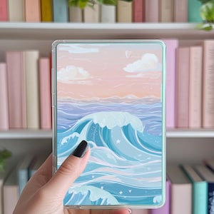 May include: A clear phone case with a colorful illustration of ocean waves and a pink sunset sky. The case has a light blue border.