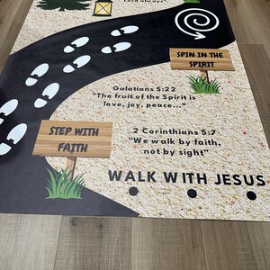 May include: A floor mat with a black road design, featuring white footprints, a tree, and a lantern. The mat includes inspirational quotes and phrases like "Step with Faith" and "Walk with Jesus."