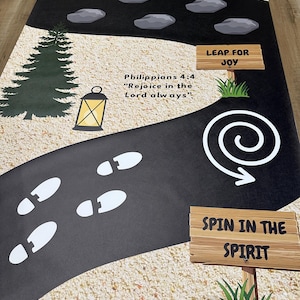 May include: A black and tan pathway featuring white footprints, rocks, and trees. The pathway includes Bible verses such as "John 14:27", "Philippians 4:4", and "Galatians 5:22". Signs read "Leap for Joy" and "Spin in the Spirit".