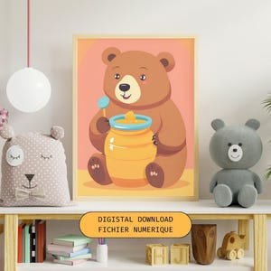 Peut inclure: Un fichier numérique imprimable représentant un ours brun en dessin animé tenant un pot de miel. L'arrière-plan est de couleur rose clair. Le texte "DIGISTAL DOWNLOAD FICHIER NUMERIQUE" est en bas de l'image.
