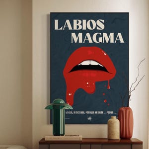 May include: A rectangular wall poster featuring the text LABIOS MAGMA in large white letters above a graphic of bright red lips with a dripping effect. The background is a dark blue with a subtle marbled texture and additional small white text.