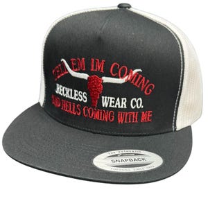 May include: Black and white trucker hat with red embroidered text that reads "Tell 'em I'm coming Reckless Wear Co. And hell's coming with me". The hat features a red skull and horns design.