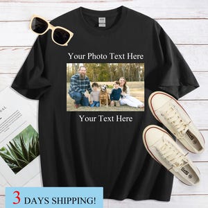 Pode incluir: Camiseta preta com foto de fam&iacute;lia e o texto "Your Photo Text Here" acima da imagem e "Your Text Here" abaixo. &Oacute;culos de sol e t&ecirc;nis brancos ao lado da camiseta. Uma revista est&aacute; &agrave; esquerda.