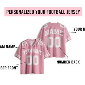 May include: Pink football jersey with white accents. The jersey features a V-neck design and includes the text "TEAM NAME" and "00" on the front. The back displays "NAME" and "00". The text "PERSONALIZED YOUR FOOTBALL JERSEY" is at the top.