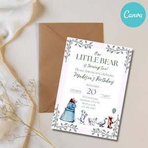 May include: A birthday invitation with the text "Our Little Bear is turning two!" and "Madison's Birthday." The invitation features illustrations of a bear, cats, ducks, and a bear holding a balloon. The invitation is on a white background with a brown envelope.