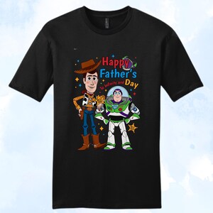 Puede incluir: Camiseta negra con Woody y Buzz Lightyear de Toy Story. El dise&ntilde;o incluye el texto "Happy Father's Day To Infinity and Beyond". Woody lleva un sombrero de vaquero y Buzz un traje espacial.