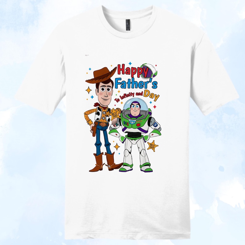 Puede incluir: Camiseta blanca con los personajes de dibujos animados Woody y Buzz Lightyear. El dise&ntilde;o incluye el texto "Happy Father's Day" y "To infinity and beyond". Woody viste un traje de vaquero, y Buzz lleva un traje espacial.