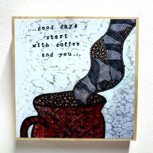 Puede incluir: Un letrero de madera con una ilustración pintada a mano de una taza de café roja con vapor saliendo de ella. El texto en el letrero dice "...good days start with coffee and you..."