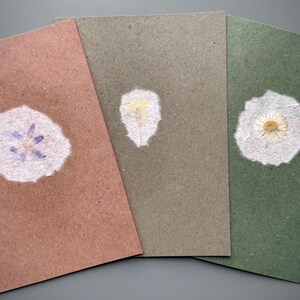 3 cartes pliantes, chacune avec une petite fleur incrustée dans du papier fait main (DIN B6)