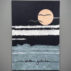 Carte de deuil « En souvenir silencieux » en papier kraft noir et bleu avec un paysage marin en papier fait main (DIN B6)