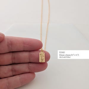 May include: A delicate gold-filled necklace featuring a rectangular pendant with an engraved floral design. The pendant measures 12mm x 6mm (&frac12;" x &frac14;"). The necklace is displayed against a white background.