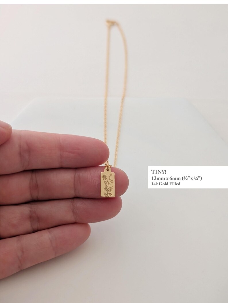 May include: A delicate gold-filled necklace featuring a rectangular pendant with an engraved floral design. The pendant measures 12mm x 6mm (&frac12;" x &frac14;"). The necklace is displayed against a white background.