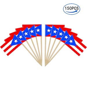 May include: A collection of small Puerto Rican flags on wooden sticks. Each flag features a blue triangle with a white star and red and white stripes. The image includes a label that reads "150PCS".