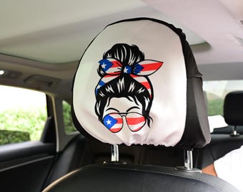 May include: A white car headrest cover featuring a graphic of a woman with a messy bun, sunglasses, and a headband in the colors of the Puerto Rican flag. The headrest cover is black on the sides.