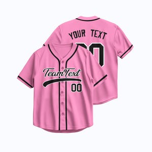 Op de afbeelding: Roze honkbalshirt met zwarte randen en knopen. Op de voorkant van het shirt staat "Team Text" met het nummer "00" eronder. Op de achterkant van het shirt staat "YOUR TEXT" met het nummer "00".