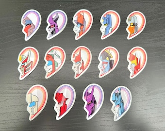 May include: Set of 12 heart-shaped stickers featuring different robot characters. Each sticker is split in half, with a rainbow design on the background. The characters are depicted in various poses and colors.