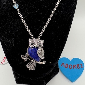 Colgante de búho con vientre de lapislázuli otoñal en una cadena de acero inoxidable con un corazón azul.