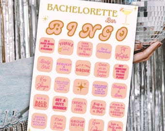 May include: A Bachelorette Bingo game card with a pink and gold design. The card features various fun challenges and activities, perfect for a bachelorette party. A disco ball is in the background.