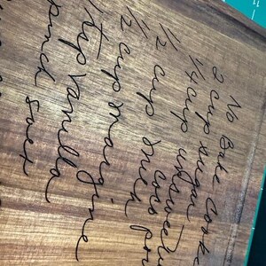 May include: A rectangular wooden cutting board featuring a laser-engraved recipe for No Bake Cookies, including ingredients like 2 cups sugar, 1/2 cup unsweetened cocoa powder, 1/2 cup milk, 1/2 cup margarine, 1 tsp vanilla, and a pinch salt.