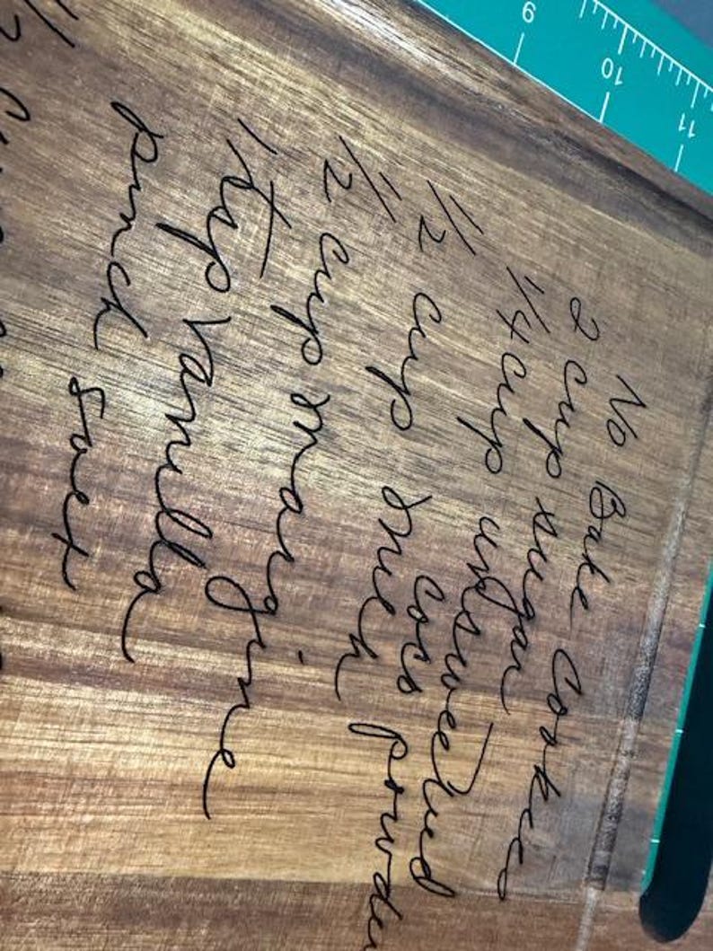 May include: A rectangular wooden cutting board featuring a laser-engraved recipe for No Bake Cookies, including ingredients like 2 cups sugar, 1/2 cup unsweetened cocoa powder, 1/2 cup milk, 1/2 cup margarine, 1 tsp vanilla, and a pinch salt.