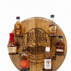 May include: A circular wooden barrel head display rack featuring the engraved text My Kentucky Bourbon Trail. The rack holds six miniature bourbon bottles including Elijah Craig, Buffalo Trace, Maker's Mark, Bulleit, Jim Beam, and Woodford Reserve.