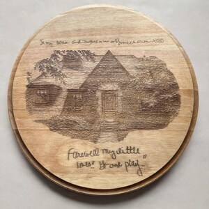 May include: A round wooden plaque featuring a laser-engraved illustration of a house surrounded by trees. The text at the top reads "To my sons and daughters in law and grandchildren XOXO" and the bottom text reads "Farewell my little ones! Go and play..."