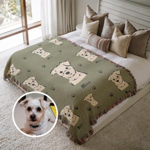 May include: A green woven throw blanket with a white dog illustration and the name "Max" repeated throughout. The blanket has a fringe border. A white dog is pictured in a circle in the lower left corner of the image.