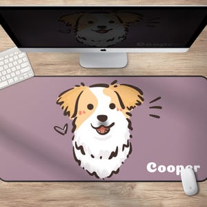 May include: A rectangular mouse pad with a cartoon dog illustration. The dog has tan and white fur, with a heart and sound effect lines. The name "Cooper" is written in white. A computer monitor, keyboard, and mouse are also visible.