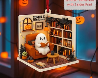 May include: A Halloween-themed ornament featuring a ghost reading in a cozy reading nook. The scene includes a bookshelf, candles, and a small table. The text "SOPHIA'S READING NOOK" is visible. The ornament is a 2D-flat design with printing on both sides.