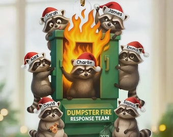May include: A Christmas ornament featuring a green dumpster engulfed in flames, with six raccoons wearing Santa hats. Each raccoon has a name on its hat. The text "Dumpster Fire Response Team" is below the dumpster.