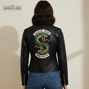 May include: Black faux leather jacket with a green and red serpent patch on the back. The patch reads "South Side Serpents" in white lettering. The jacket has a zipper closure and zippers on the sleeves.