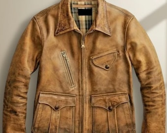 May include: A distressed brown leather jacket with a zip-up front, a collared neckline, and multiple pockets. The jacket features a plaid lining visible at the collar and a diagonal zippered chest pocket. The leather has a worn, vintage appearance.