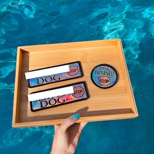 May include: Two rectangular patches and one circular patch with a holographic finish and black borders. The rectangular patches feature the word DOG and a red stop sign icon. The circular patch features the text TASK TRAINED and a red stop sign icon.
