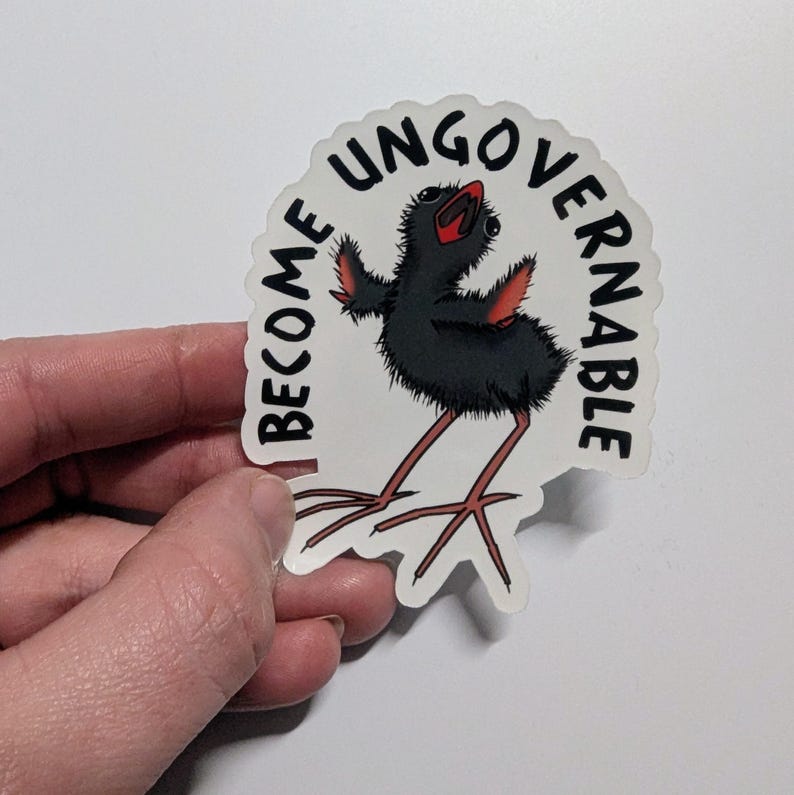 May include: A sticker with a cartoon bird design. The bird has black feathers, red accents, and long legs. The sticker has the words "I BECOME UNGOVERNABLE" in black text, set within a white scalloped border.