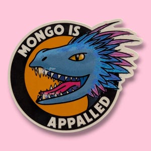 May include: A sticker featuring a cartoon dragon with blue scales, a pink tongue, and yellow eyes. The dragon is inside a black-bordered circle with the words "MONGO IS APPALLED" in white.