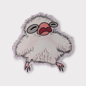 May include: A sticker featuring a cartoon illustration of a fluffy, white creature with a pink beak and open mouth. The creature has gray eyes and small, pink feet. The sticker has a light purple outline.