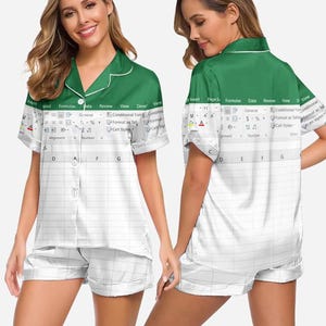 May include: A white and green pyjama set with a spreadsheet design. The top has a green collar and trim, with a button-down front. The shorts match the top's design. The spreadsheet design includes text like "Formulas" and "Data".
